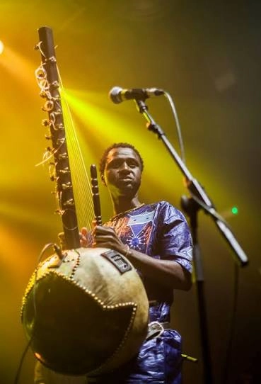 Jali Bakary Konteh performing with a kora under stage lights